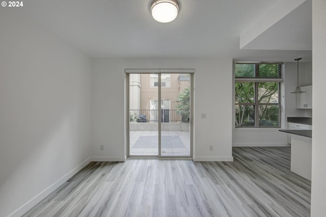 unfurnished dining area with wood finished floors and baseboards