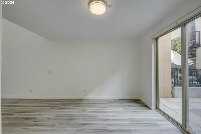 unfurnished room with light wood-style floors and baseboards