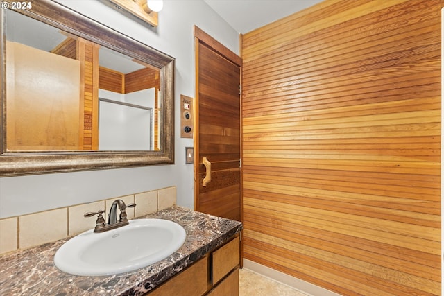 bathroom with vanity and wood walls