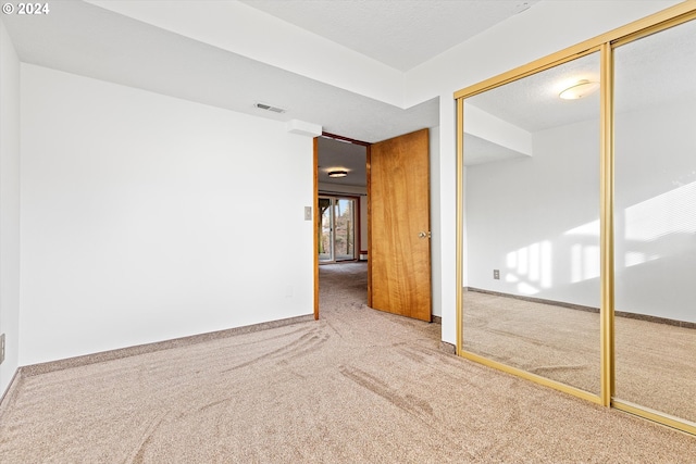 carpeted empty room with a textured ceiling