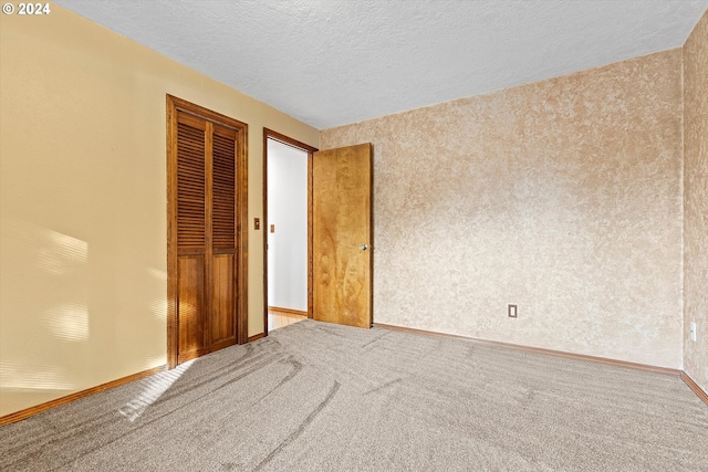 unfurnished bedroom featuring a closet, carpet, and a textured ceiling