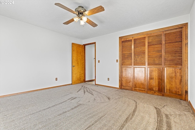 unfurnished bedroom featuring carpet, a textured ceiling, a closet, and ceiling fan