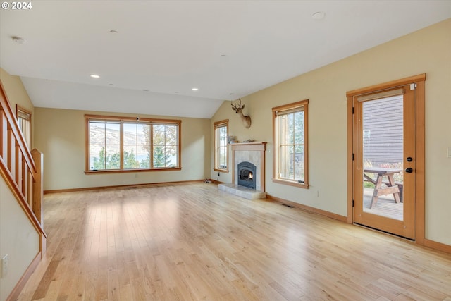 unfurnished living room featuring lofted ceiling and light wood-type flooring