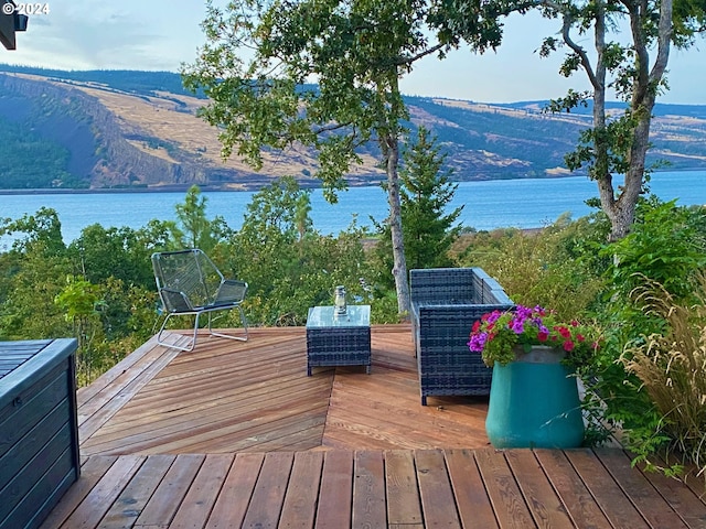 wooden terrace with a water and mountain view