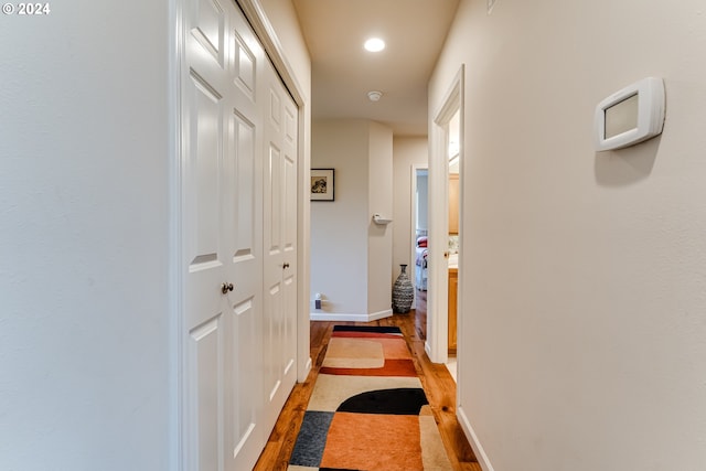 hall featuring light wood-style flooring, baseboards, and recessed lighting