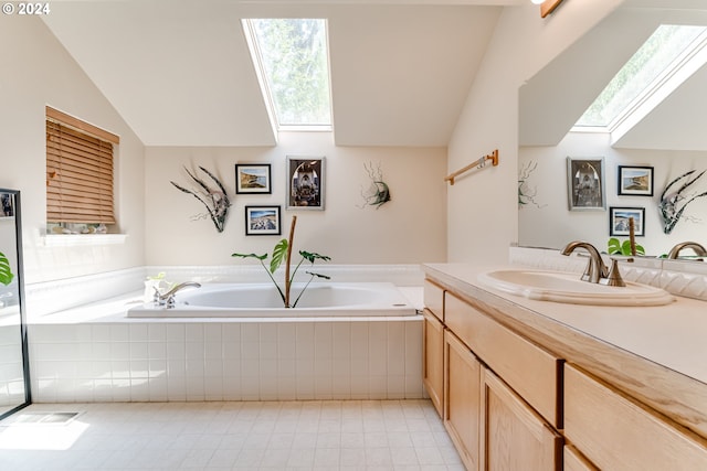 full bath with vaulted ceiling with skylight, a garden tub, vanity, and tile patterned floors