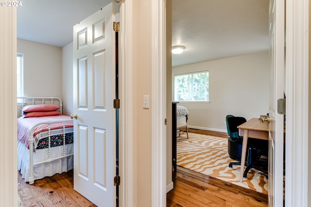 bedroom with wood finished floors and baseboards