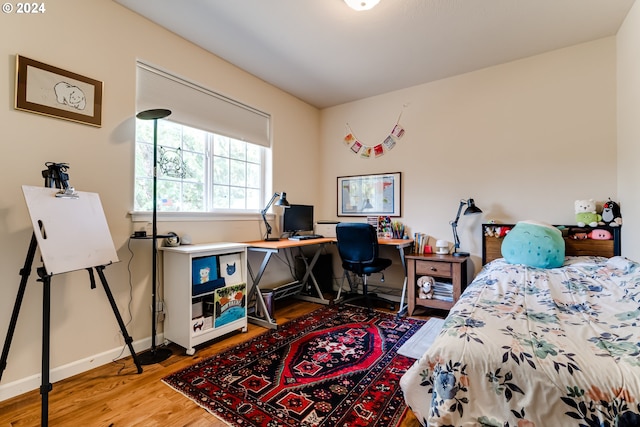 bedroom with baseboards and wood finished floors