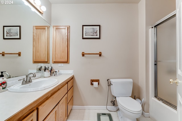 full bath featuring combined bath / shower with glass door, vanity, toilet, and baseboards