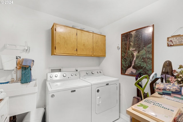 laundry area featuring washer and clothes dryer, cabinets, and sink