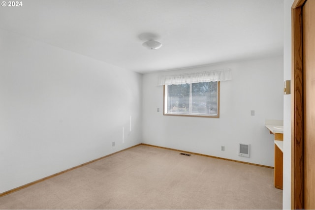 empty room with light carpet and heating unit