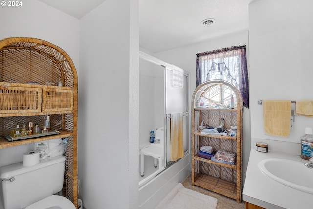 full bathroom with bath / shower combo with glass door, toilet, sink, and tile patterned floors