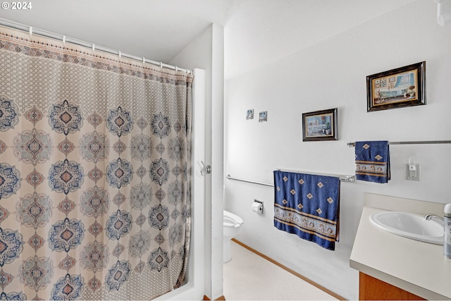 bathroom with walk in shower, vanity, and toilet