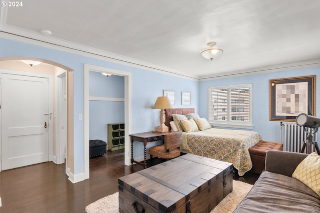 bedroom with ornamental molding, dark wood-type flooring, and radiator heating unit