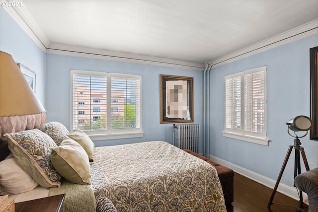 bedroom with ornamental molding, radiator heating unit, and hardwood / wood-style floors