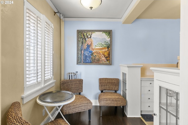 living area with plenty of natural light, crown molding, and hardwood / wood-style flooring