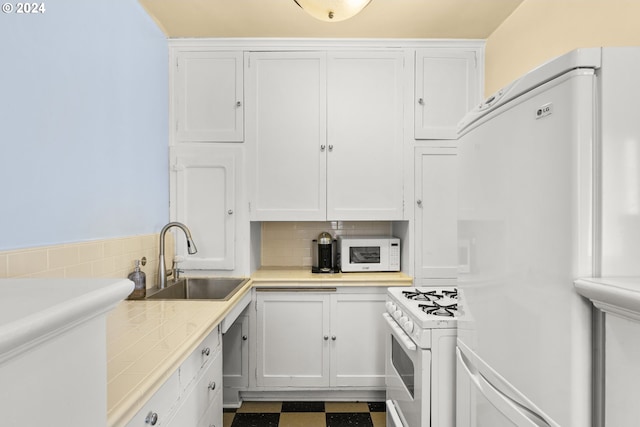 kitchen with white cabinets, white appliances, backsplash, tile flooring, and sink