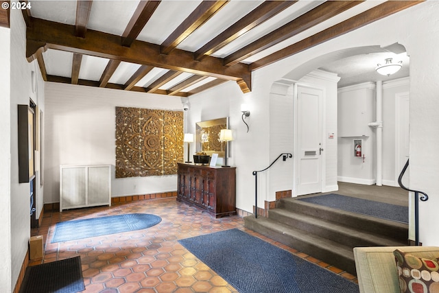 interior space featuring tile flooring and beamed ceiling