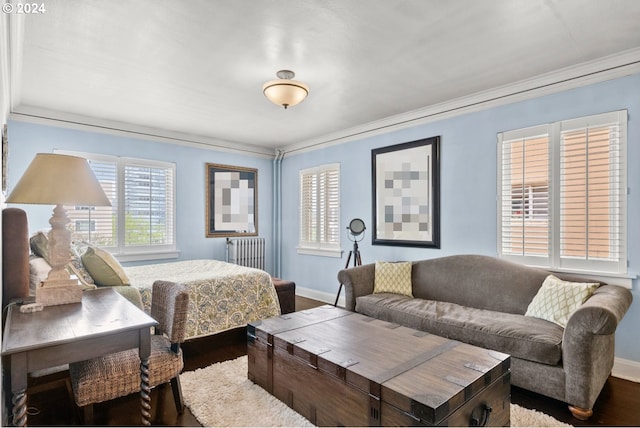 bedroom with radiator heating unit, dark wood-type flooring, and ornamental molding