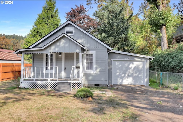 view of front of house featuring covered porch, a front lawn, and a garage