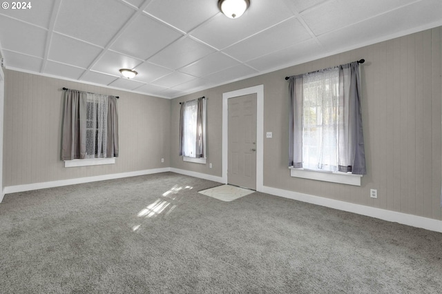 spare room with a paneled ceiling and carpet flooring