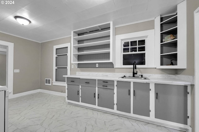 kitchen featuring sink, gray cabinetry, and crown molding