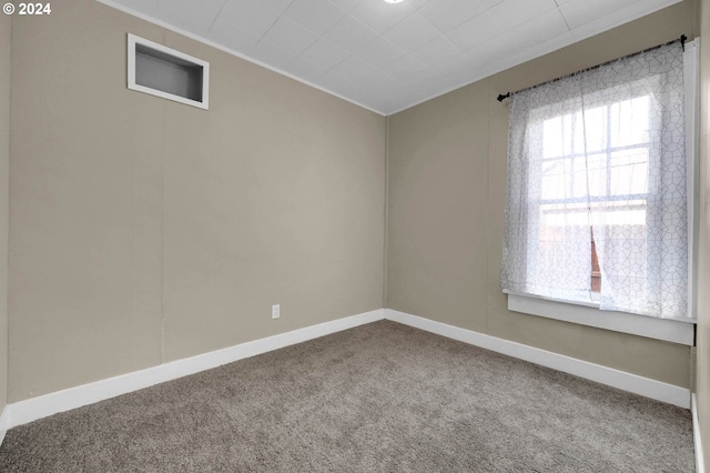 carpeted spare room featuring crown molding