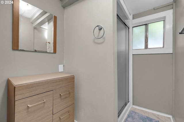 bathroom featuring a shower with door and vanity