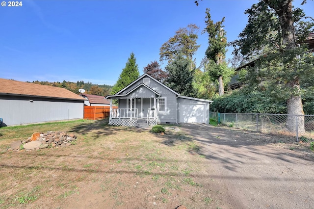 view of front of house with a front yard, an outbuilding, and a garage