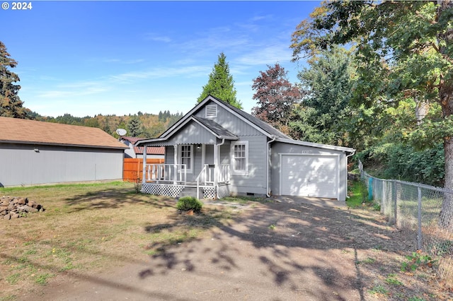 ranch-style house with covered porch, a garage, and a front yard