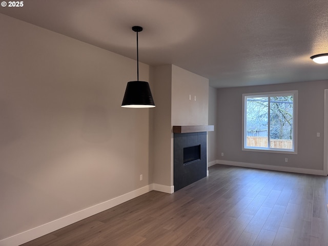 unfurnished living room with a textured ceiling, a fireplace, and dark hardwood / wood-style floors