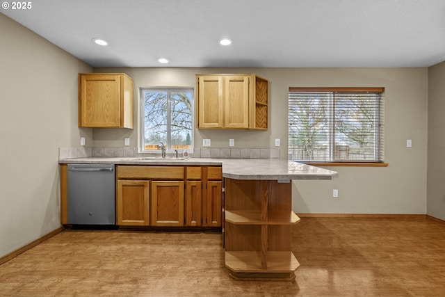 kitchen with sink, dishwasher, light carpet, kitchen peninsula, and a breakfast bar area