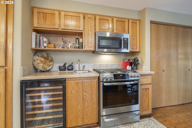 kitchen featuring appliances with stainless steel finishes, beverage cooler, and sink