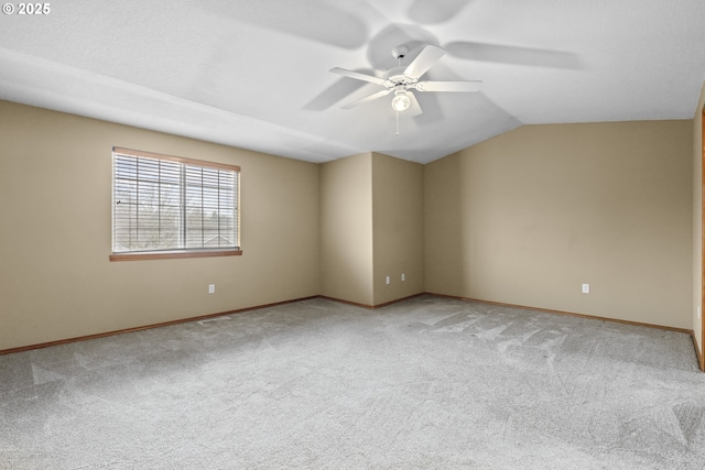 carpeted empty room featuring ceiling fan and vaulted ceiling