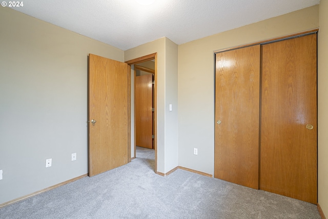 unfurnished bedroom featuring light colored carpet and a closet