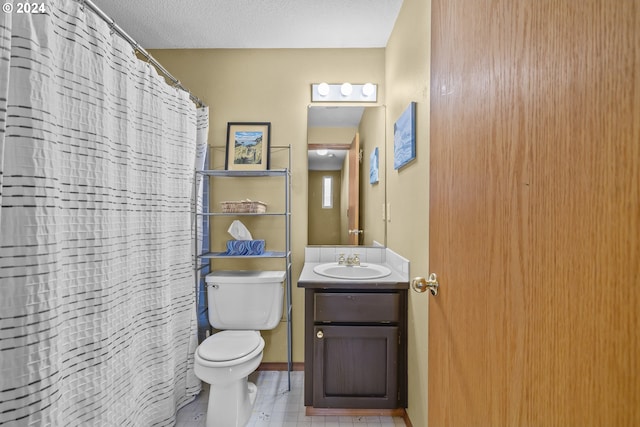 bathroom with a textured ceiling, a shower with curtain, vanity, and toilet