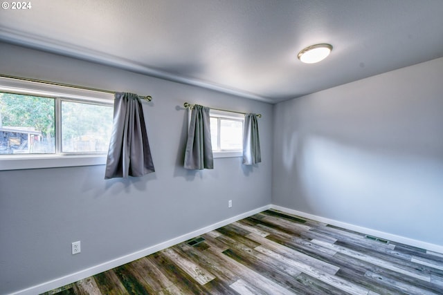 spare room featuring hardwood / wood-style flooring and a healthy amount of sunlight