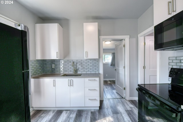 kitchen with black appliances, white cabinetry, and sink