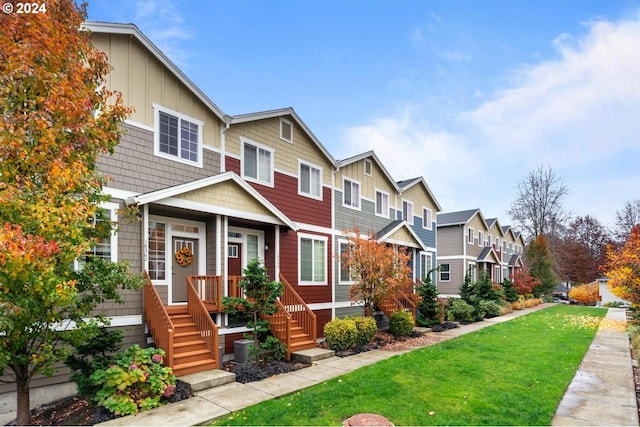 townhome / multi-family property featuring board and batten siding, a residential view, and a front lawn