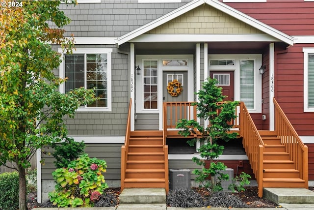 view of exterior entry featuring central AC unit and covered porch