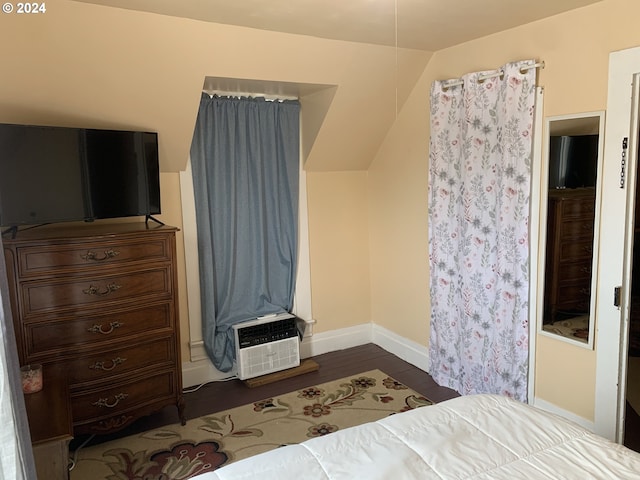 bedroom featuring cooling unit, dark hardwood / wood-style flooring, and vaulted ceiling