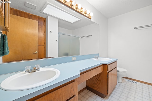 bathroom featuring tile patterned floors, double vanity, a stall shower, and a sink