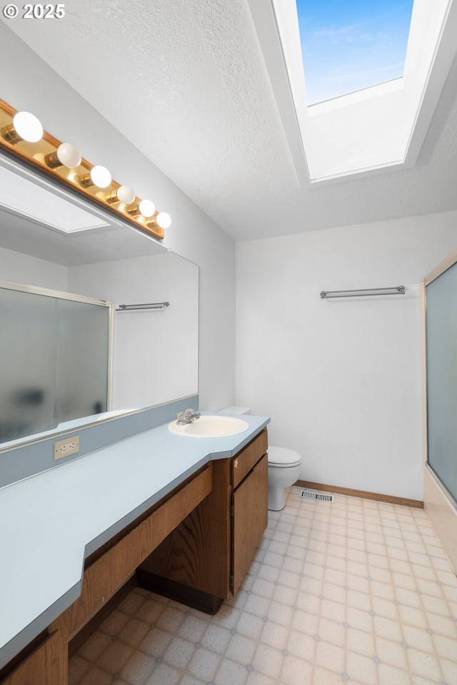 bathroom with a skylight, visible vents, tile patterned floors, a textured ceiling, and vanity