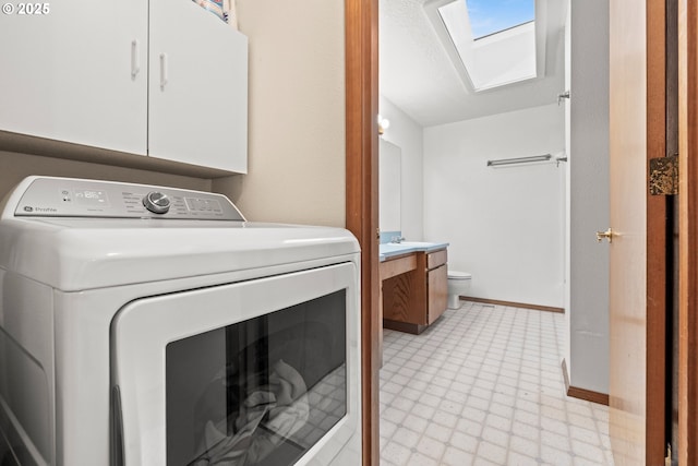 washroom featuring a skylight, cabinet space, and washer / dryer