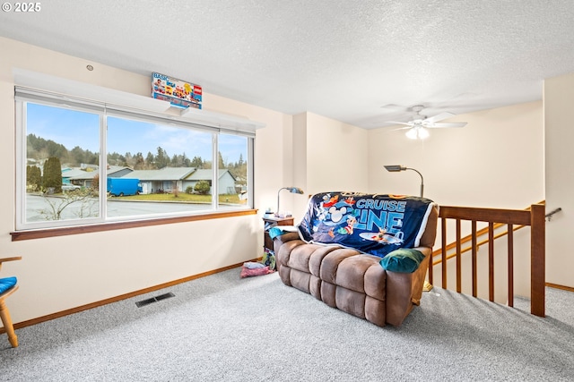 carpeted living room with a textured ceiling, visible vents, and baseboards