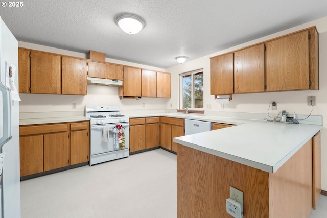 kitchen featuring a sink, under cabinet range hood, white appliances, a peninsula, and light countertops