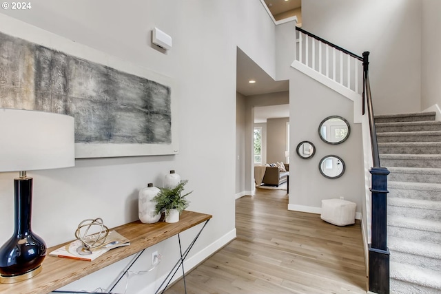 foyer featuring a towering ceiling and light hardwood / wood-style flooring