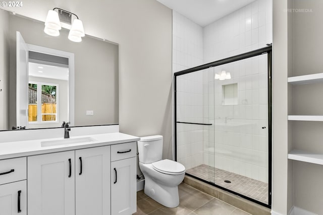 bathroom with vanity, toilet, walk in shower, and tile patterned flooring