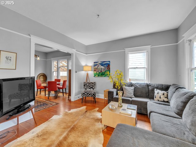 living area featuring light wood-style floors, baseboards, and a wealth of natural light