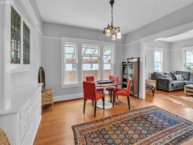 dining room featuring a chandelier, light wood finished floors, and baseboards